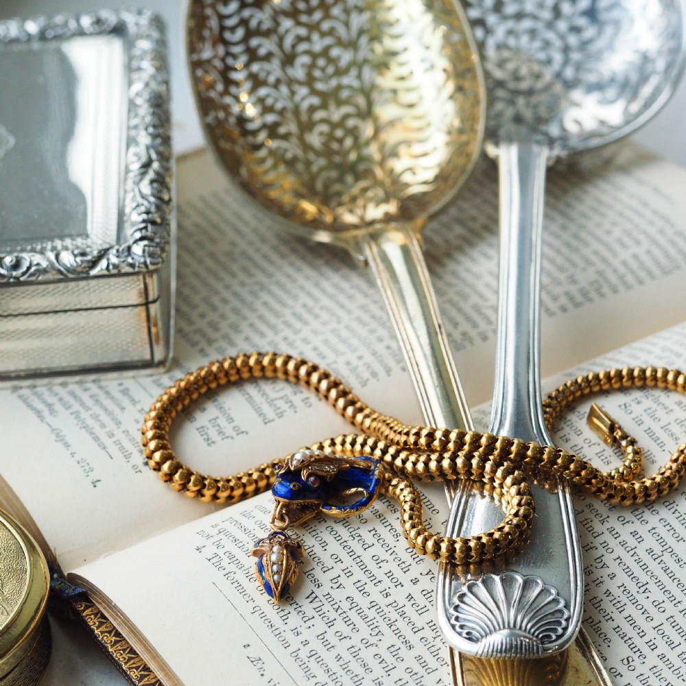 A Victorian 18-carat gold woven chain necklace featuring a blue enamel snake head set with seed pearls, small diamonds, and ruby eyes. View VI