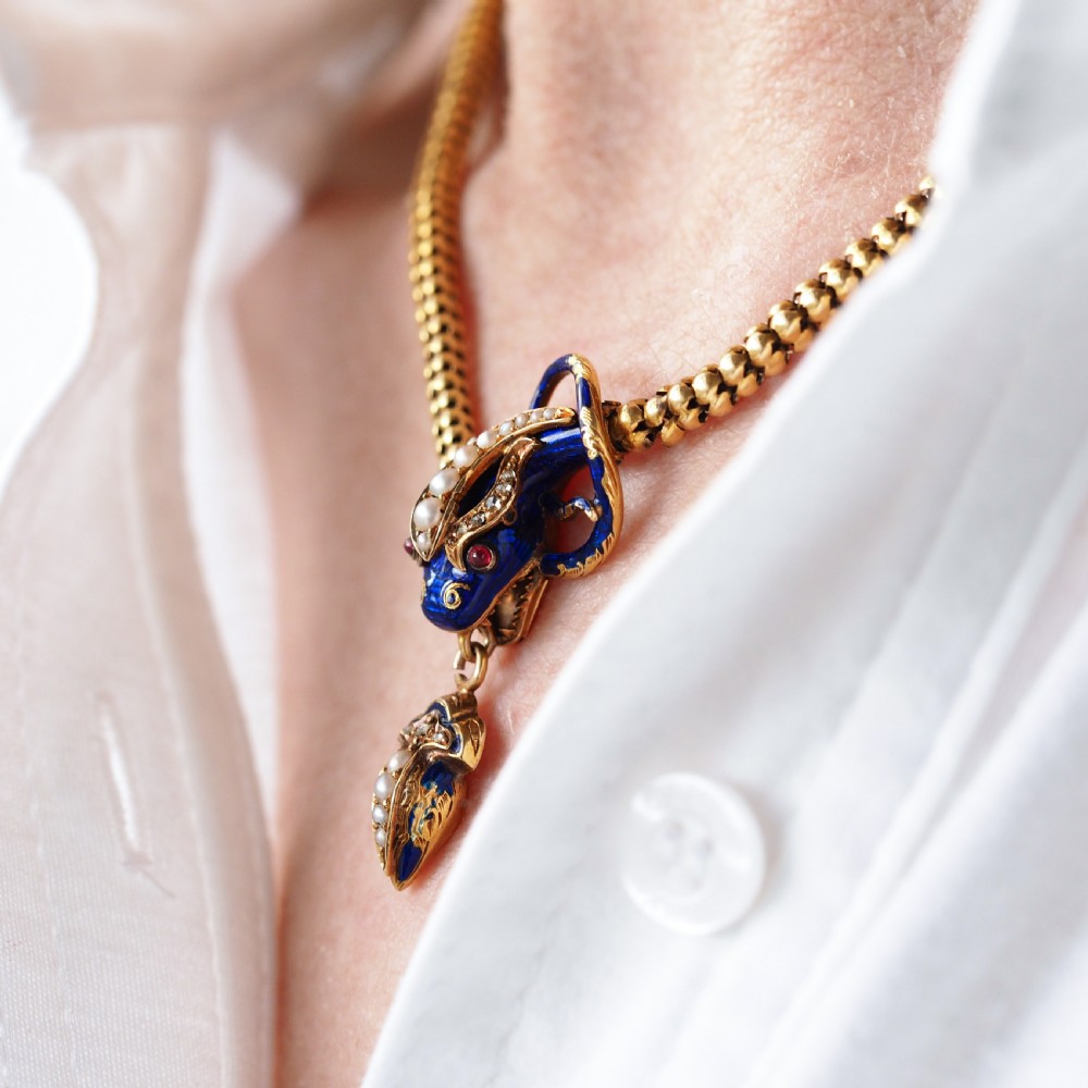 A Victorian 18-carat gold woven chain necklace featuring a blue enamel snake head set with seed pearls, small diamonds, and ruby eyes. View VII
