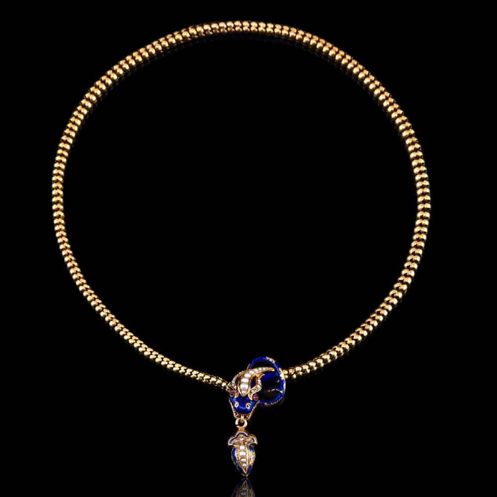An antique Victorian 18-carat gold snake necklace featuring a flexible chain and a blue enamel serpent head decorated with seed pearls and diamonds. View XVI