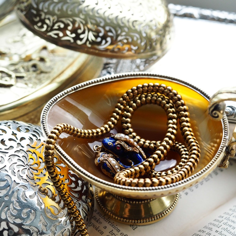 An antique Victorian 18-carat gold snake necklace featuring a flexible chain and a blue enamel serpent head decorated with seed pearls and diamonds. View XX