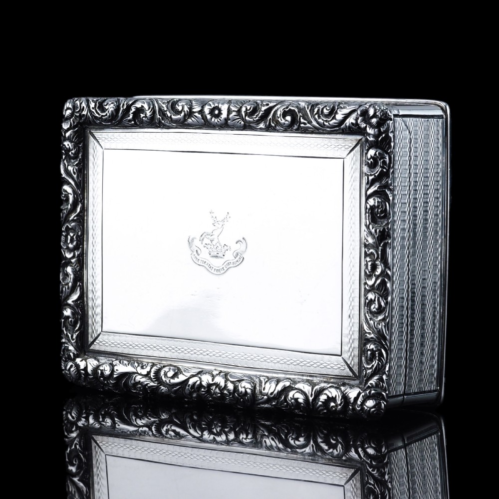 A rectangular sterling silver Georgian snuff box featuring a chased floral border, engine-turned detailing, and a central engraved crest. View VII