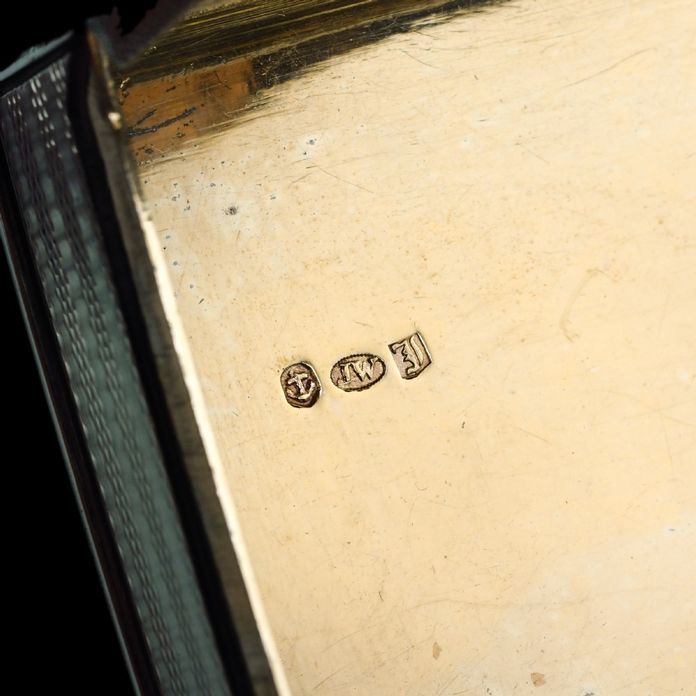 A rectangular sterling silver Georgian snuff box featuring a chased floral border, engine-turned detailing, and a central engraved crest. View XI