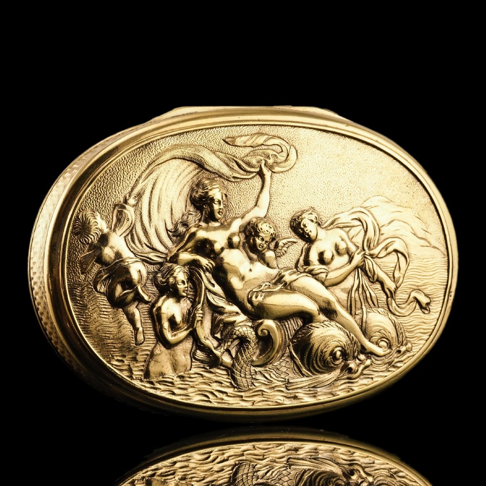 An oval Georgian silver-gilt snuff box featuring a detailed relief depicting Venus surrounded by attendants and cherubs on a textured ground. View V