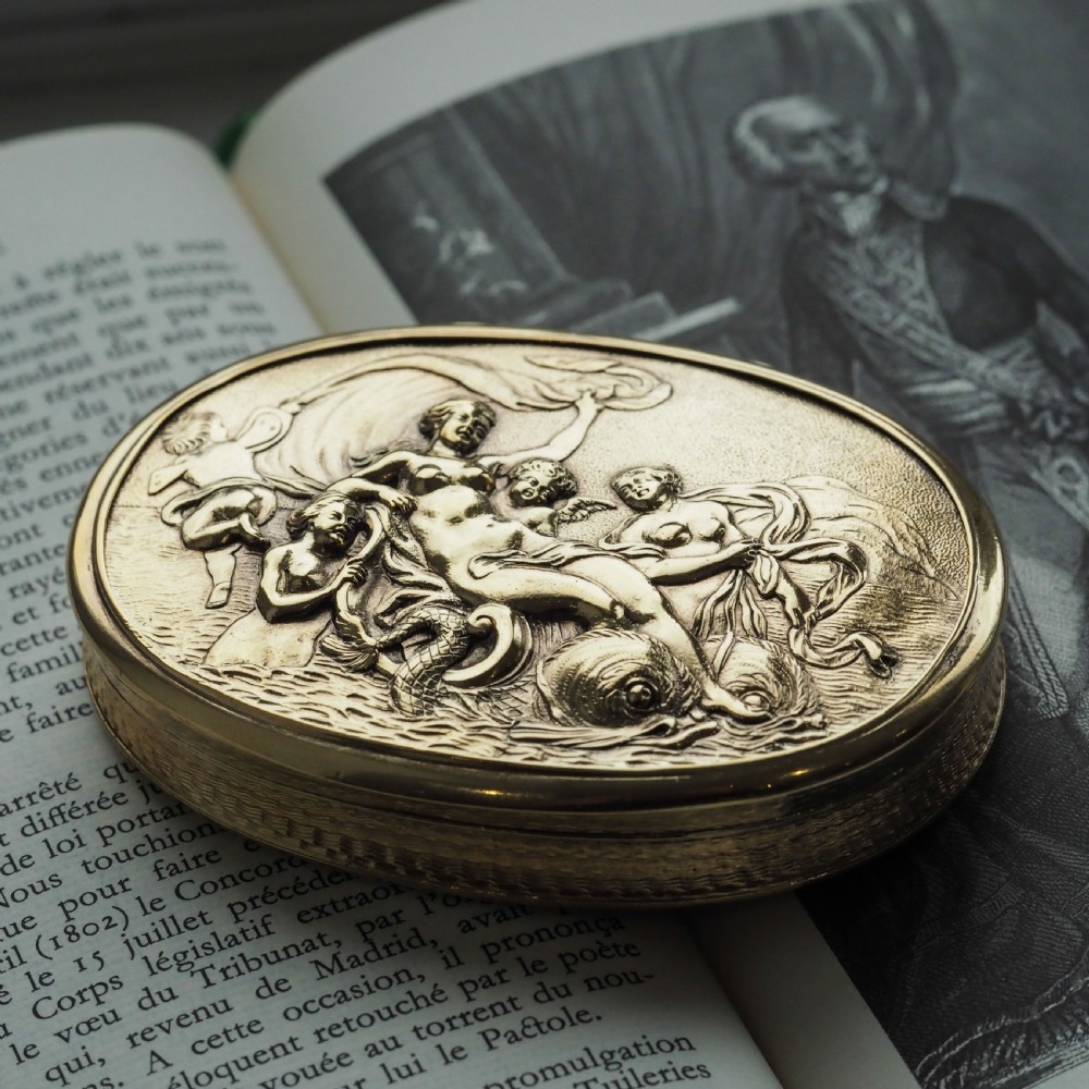 An oval Georgian silver-gilt snuff box featuring a detailed relief depicting Venus surrounded by attendants and cherubs on a textured ground. View VIII