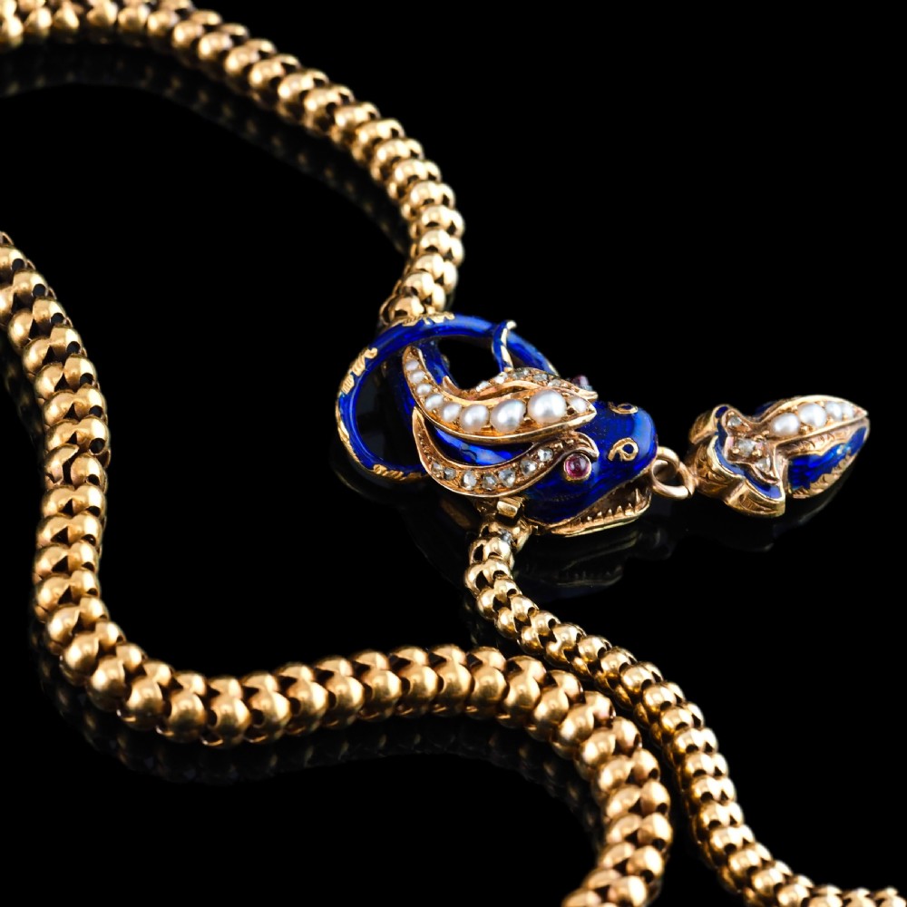 An antique Victorian 18-carat gold snake necklace featuring a flexible chain and a blue enamel serpent head decorated with seed pearls and diamonds. View XI