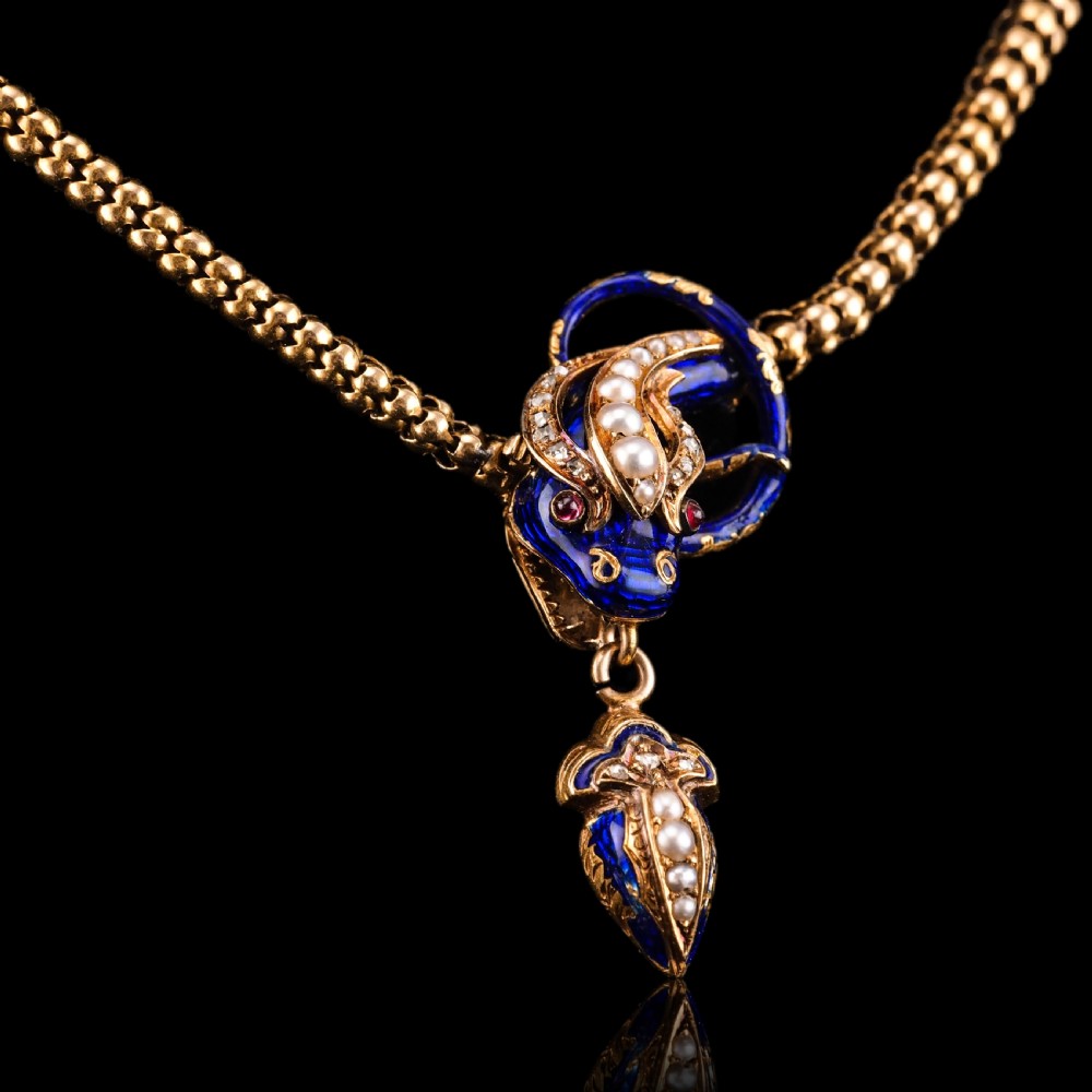 An antique Victorian 18-carat gold snake necklace featuring a flexible chain and a blue enamel serpent head decorated with seed pearls and diamonds. View XII
