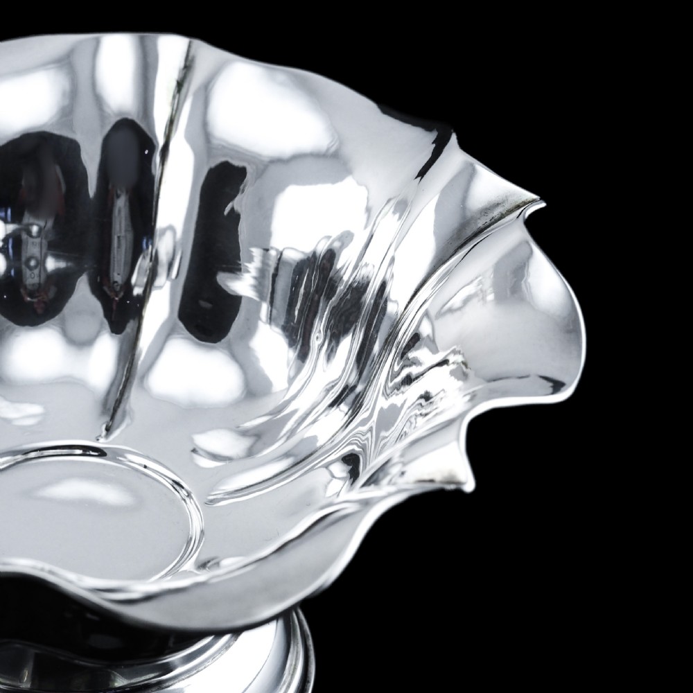 An antique Austro-Hungarian solid silver bowl featuring a flared, scalloped rim reminiscent of a floral blossom with a polished reflective finish. View VI
