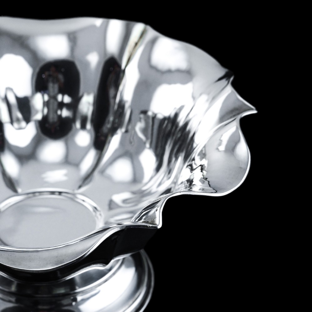 An antique Austro-Hungarian solid silver bowl featuring a flared, scalloped rim reminiscent of a floral blossom with a polished reflective finish. View VII