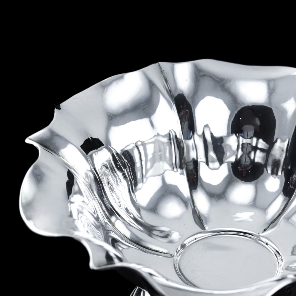 An antique Austro-Hungarian solid silver bowl featuring a flared, scalloped rim reminiscent of a floral blossom with a polished reflective finish. View VIII