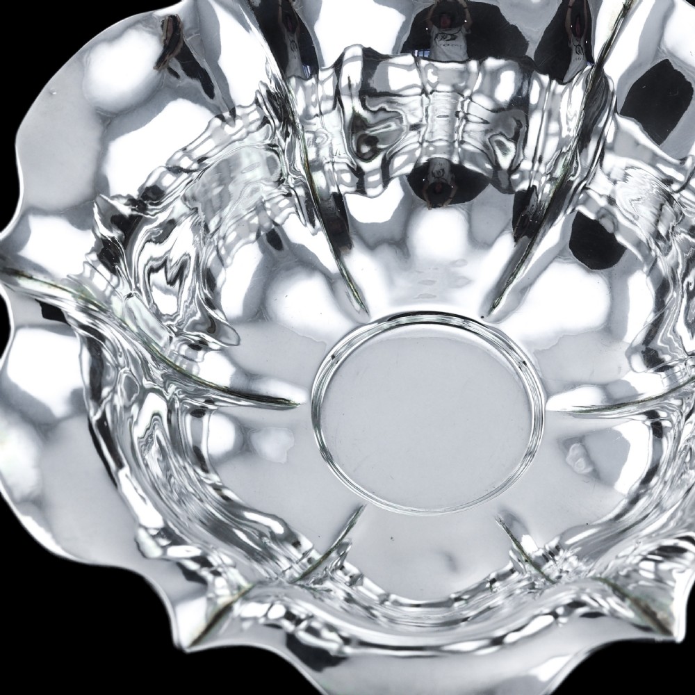 An antique Austro-Hungarian solid silver bowl featuring a flared, scalloped rim reminiscent of a floral blossom with a polished reflective finish. View IX