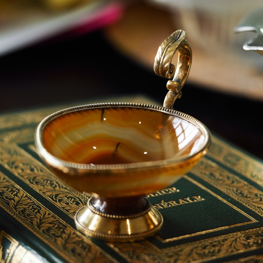 A 19th-century carved brown banded agate cup featuring a silver-gilt rim, pedestal base, and an ornate scroll handle. View III