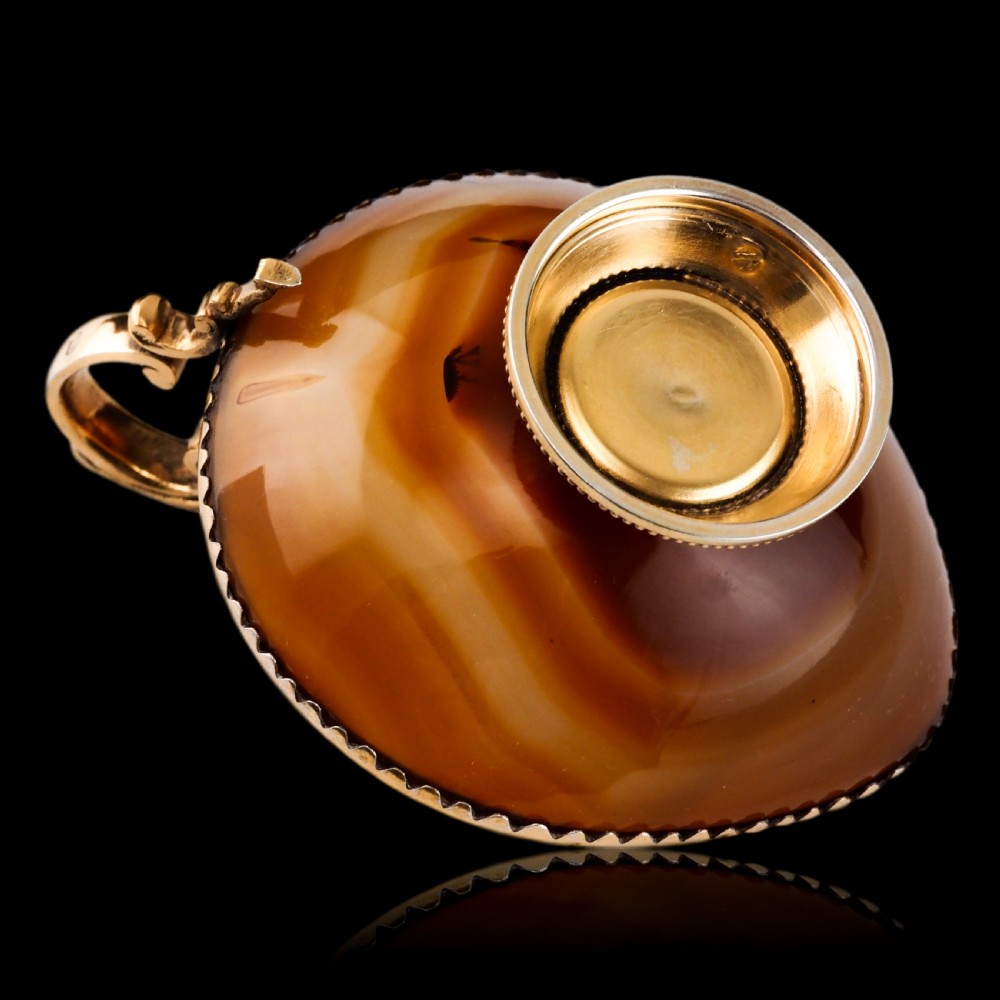 A 19th-century carved brown banded agate cup featuring a silver-gilt rim, pedestal base, and an ornate scroll handle. View XIII