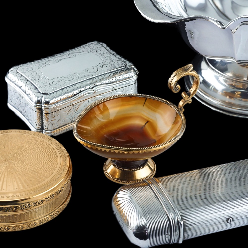 A 19th-century carved brown banded agate cup featuring a silver-gilt rim, pedestal base, and an ornate scroll handle. View XVIII