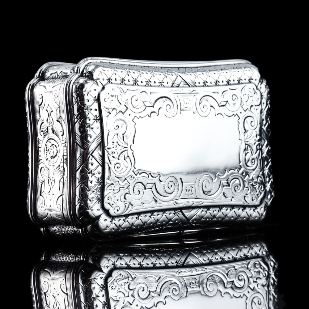 A Victorian sterling silver table snuff box with shaped cartouche outlines, foliage engraving, and an architectural scene. View XIV