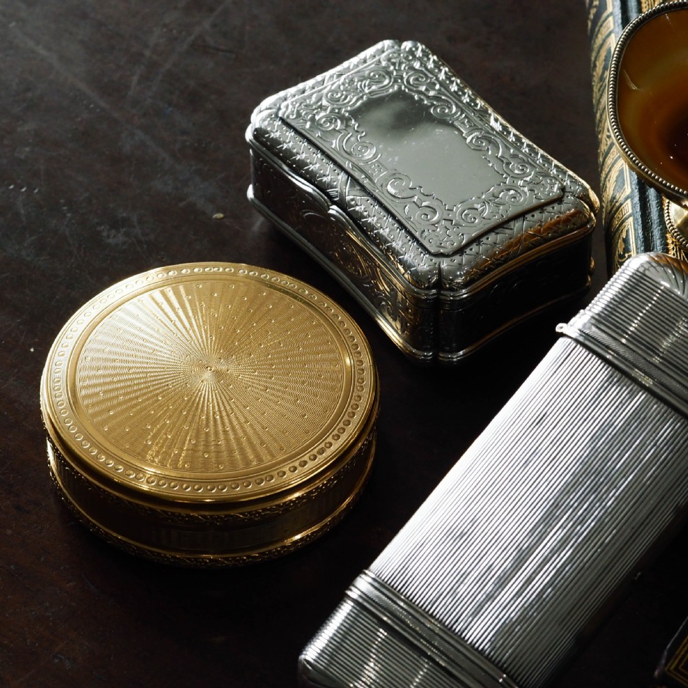 A Victorian sterling silver table snuff box with shaped cartouche outlines, foliage engraving, and an architectural scene. View XXV
