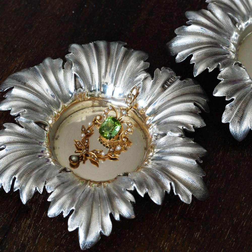 Pair of Victorian sterling silver open salt dishes featuring detailed chased leaf motifs radiating around a central polished circular well. View IV