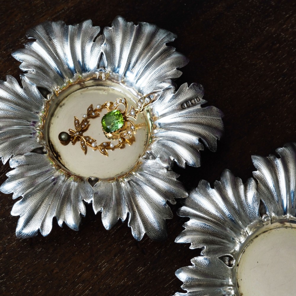 Pair of Victorian sterling silver open salt dishes featuring detailed chased leaf motifs radiating around a central polished circular well. View V