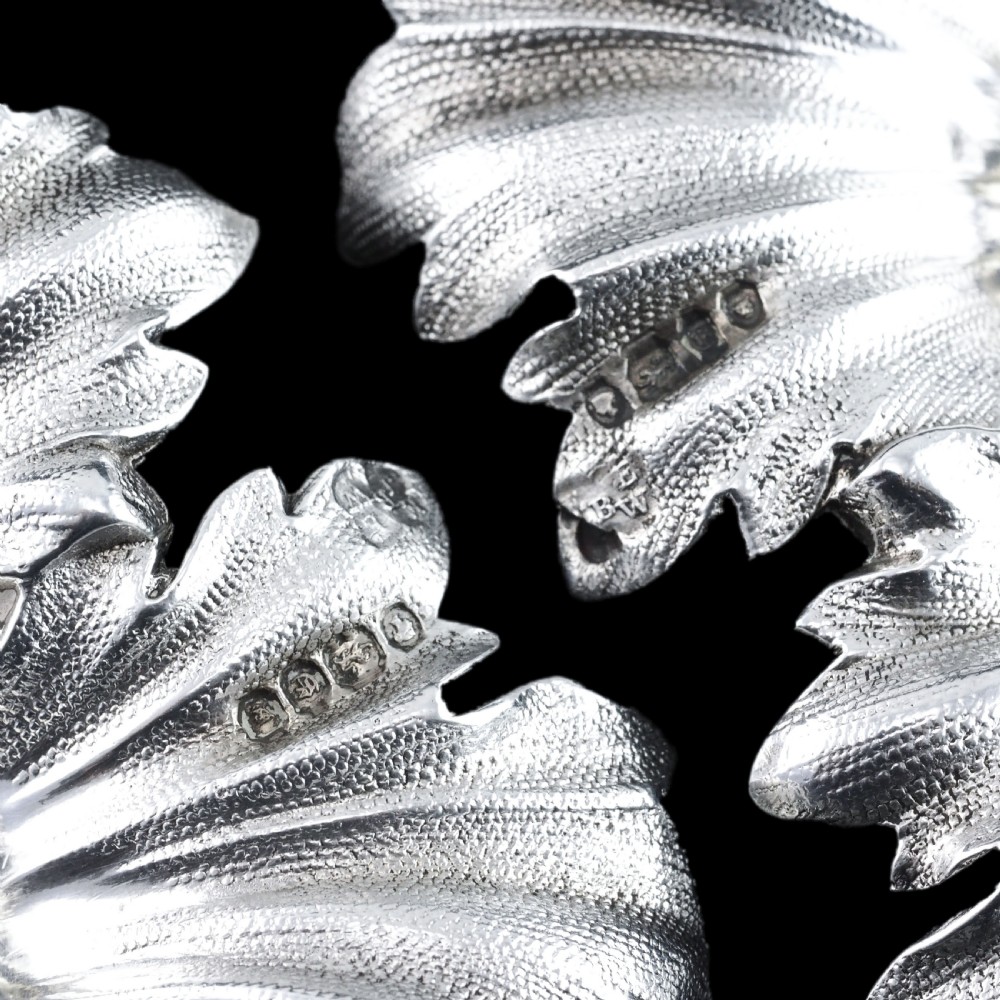 Pair of Victorian sterling silver open salt dishes featuring detailed chased leaf motifs radiating around a central polished circular well. View VIII