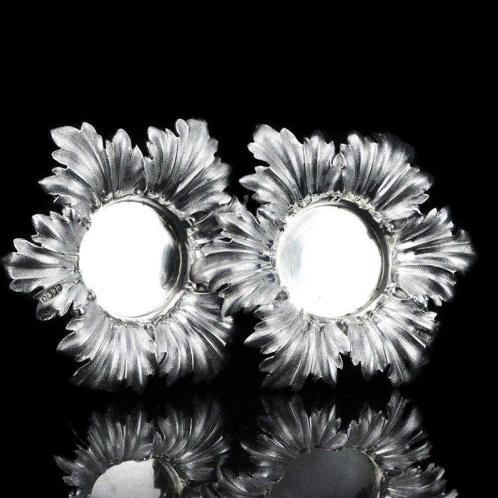 Pair of Victorian sterling silver open salt dishes featuring detailed chased leaf motifs radiating around a central polished circular well. View XII