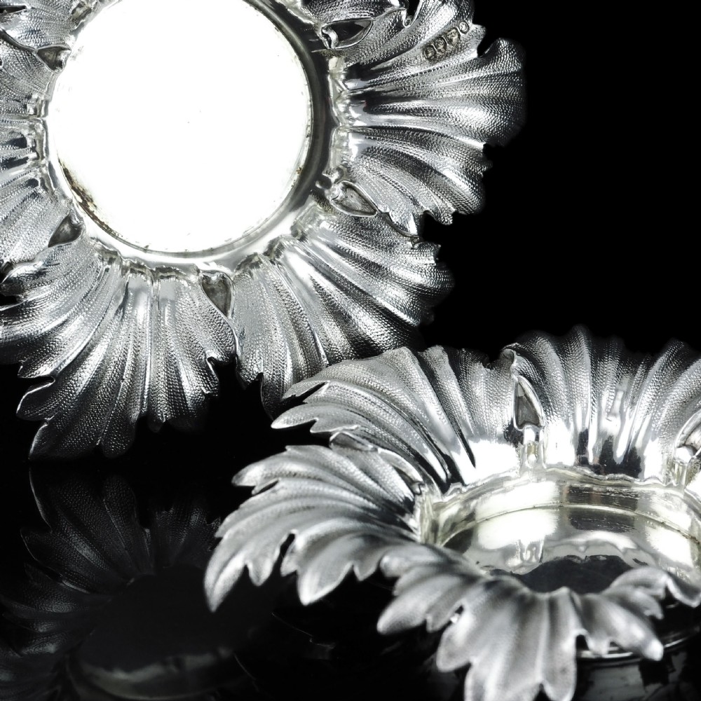 Pair of Victorian sterling silver open salt dishes featuring detailed chased leaf motifs radiating around a central polished circular well. View XIII