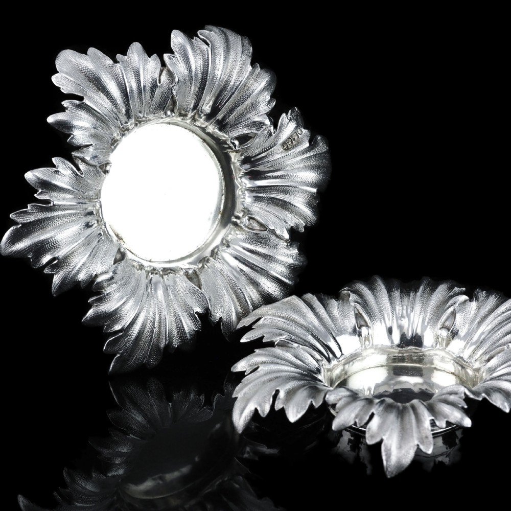 Pair of Victorian sterling silver open salt dishes featuring detailed chased leaf motifs radiating around a central polished circular well. View XIV