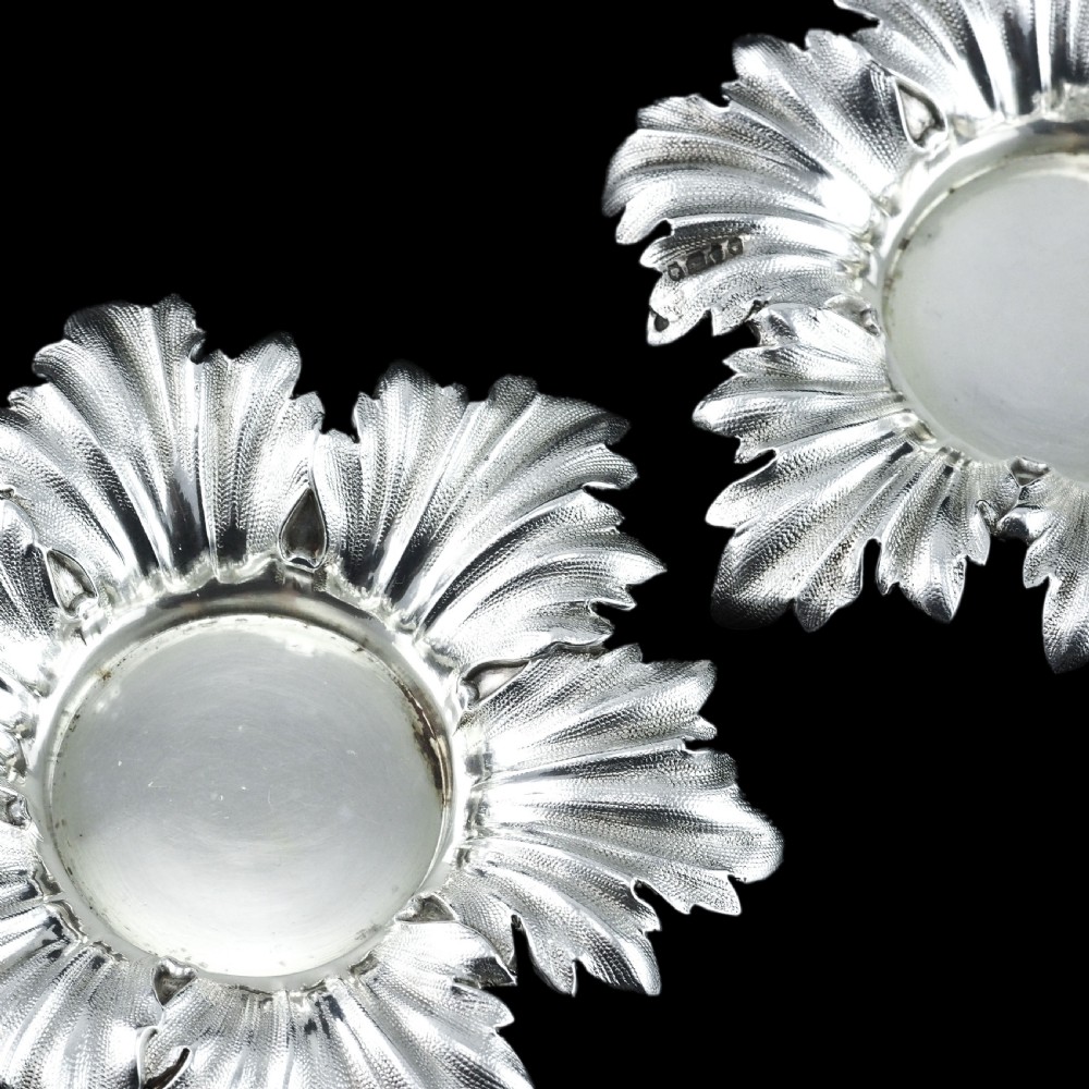 Pair of Victorian sterling silver open salt dishes featuring detailed chased leaf motifs radiating around a central polished circular well. View XVIII
