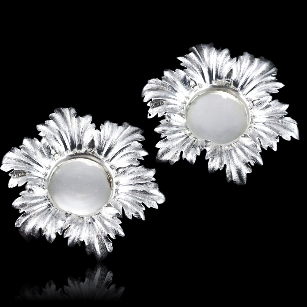 Pair of Victorian sterling silver open salt dishes featuring detailed chased leaf motifs radiating around a central polished circular well. View XIX