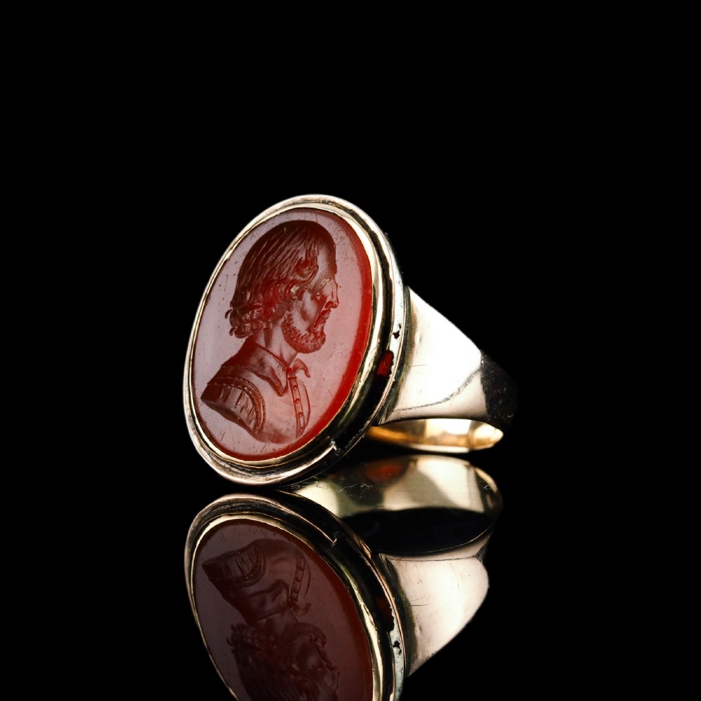 An antique gold signet ring featuring an oval red carnelian gemstone carved with the side profile portrait of a gentleman. View II