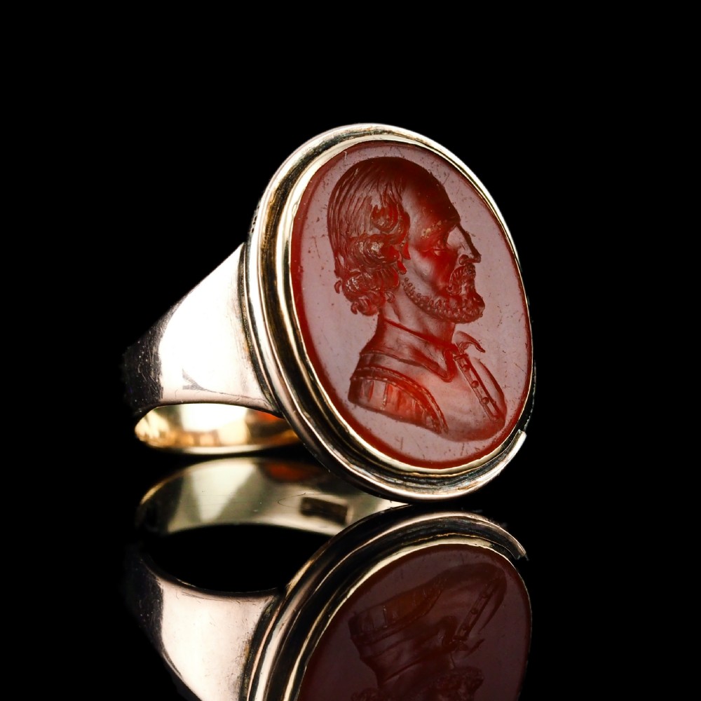 An antique gold signet ring featuring an oval red carnelian gemstone carved with the side profile portrait of a gentleman. View III