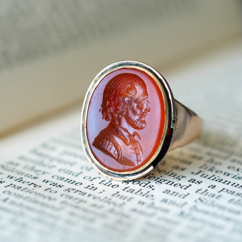 An antique gold signet ring featuring an oval red carnelian gemstone carved with the side profile portrait of a gentleman. View VI