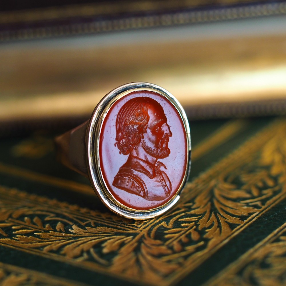 An antique gold signet ring featuring an oval red carnelian gemstone carved with the side profile portrait of a gentleman. View VIII