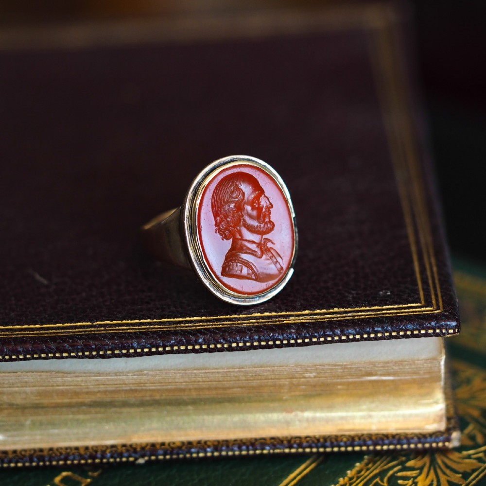 An antique gold signet ring featuring an oval red carnelian gemstone carved with the side profile portrait of a gentleman. View IX