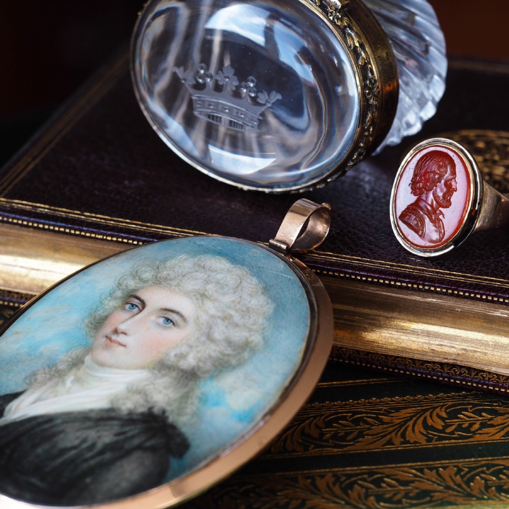 An antique gold signet ring featuring an oval red carnelian gemstone carved with the side profile portrait of a gentleman. View XII
