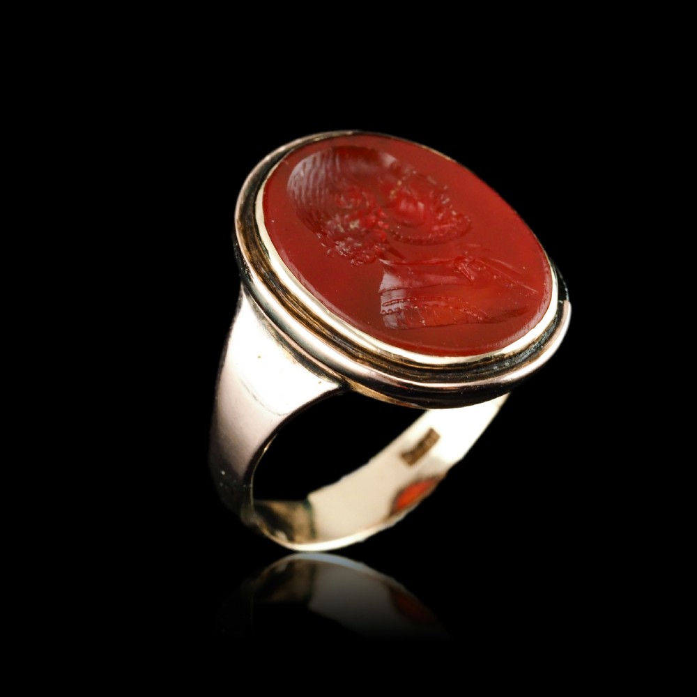 An antique gold signet ring featuring an oval red carnelian gemstone carved with the side profile portrait of a gentleman. View XVII
