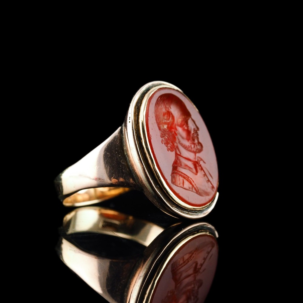 An antique gold signet ring featuring an oval red carnelian gemstone carved with the side profile portrait of a gentleman. View XIX