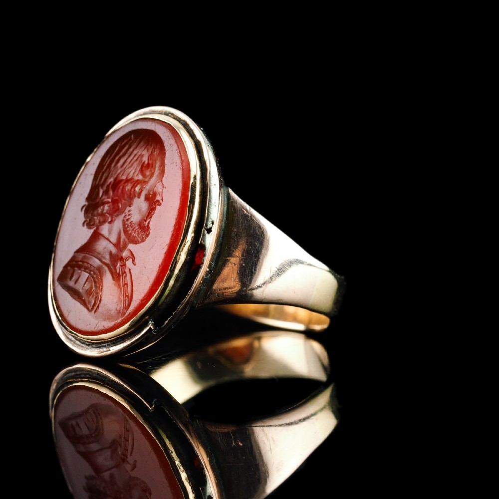An antique gold signet ring featuring an oval red carnelian gemstone carved with the side profile portrait of a gentleman. View XX