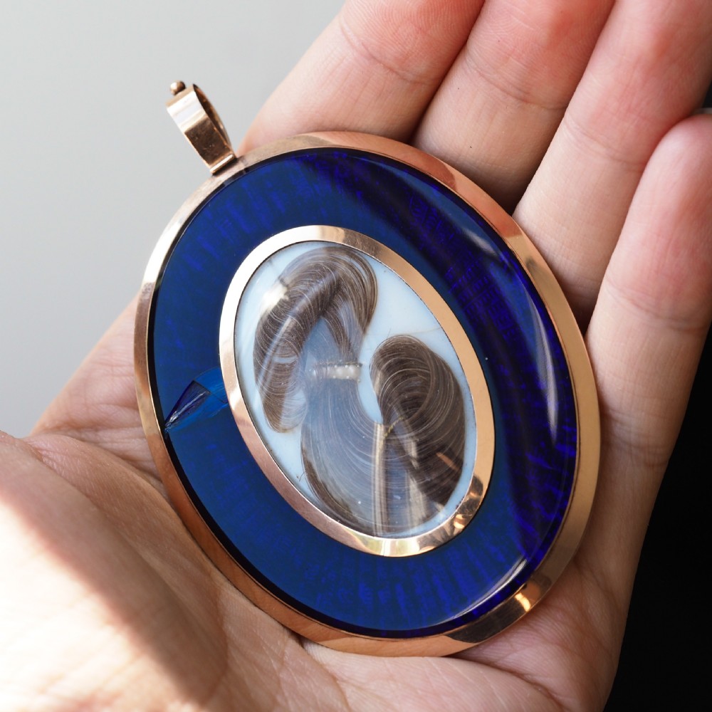 An oval Georgian portrait miniature depicting a subject with light powdered hair set in a 14k gold frame with a top bail. View XI
