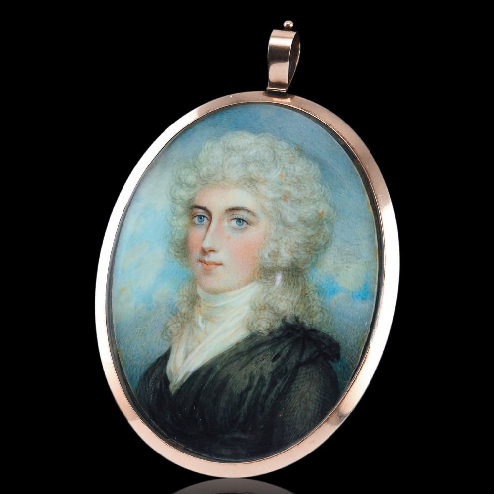 An oval Georgian portrait miniature depicting a subject with light powdered hair set in a 14k gold frame with a top bail. View XIV