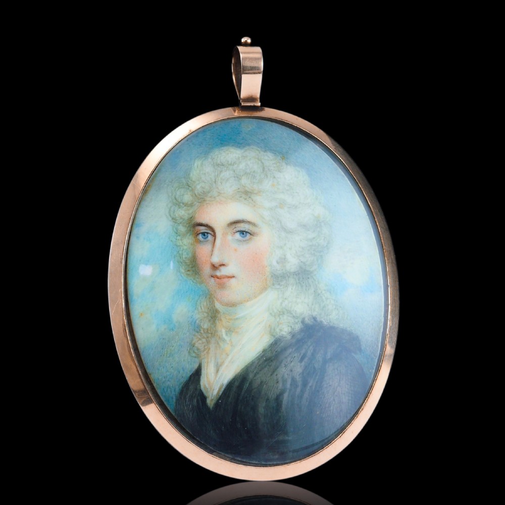 An oval Georgian portrait miniature depicting a subject with light powdered hair set in a 14k gold frame with a top bail. View XVIII