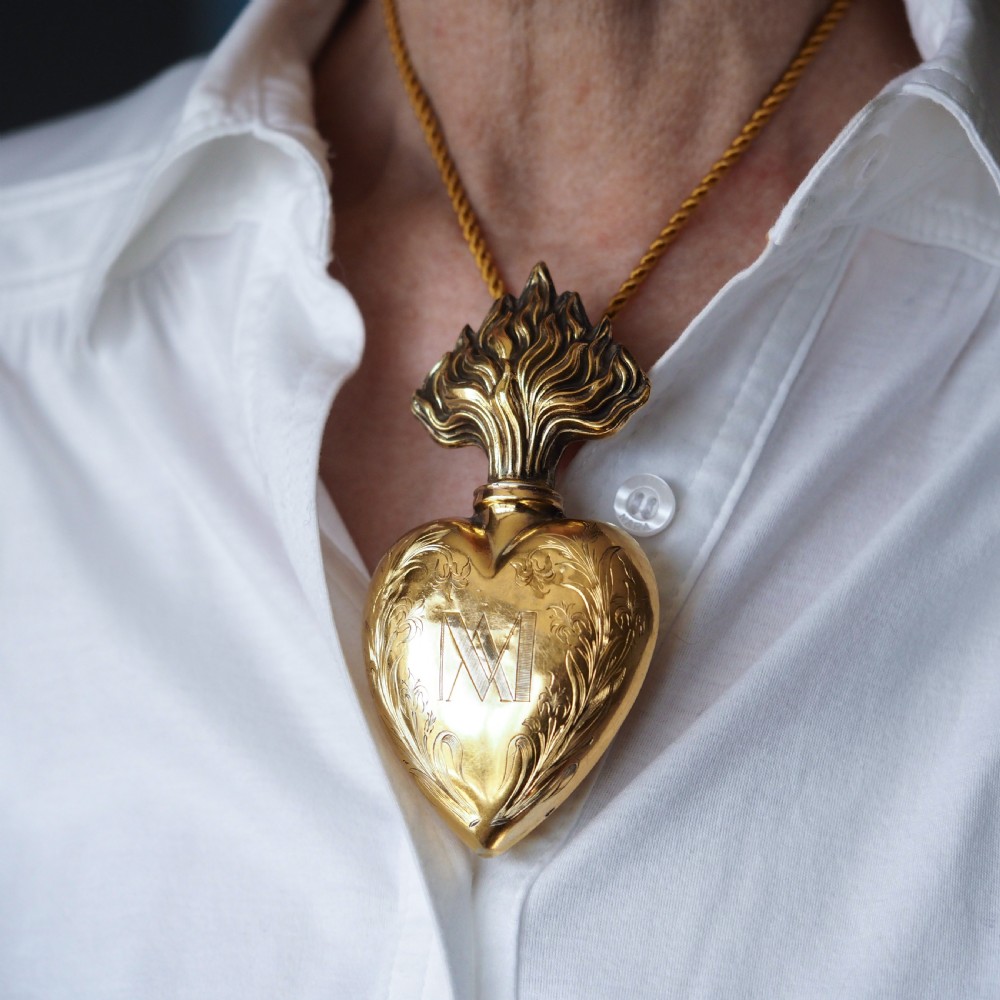A 19th-century French silver-gilt heart-shaped scent bottle featuring an engraved monogram, foliate scrollwork, and a flame-shaped stopper. View XI