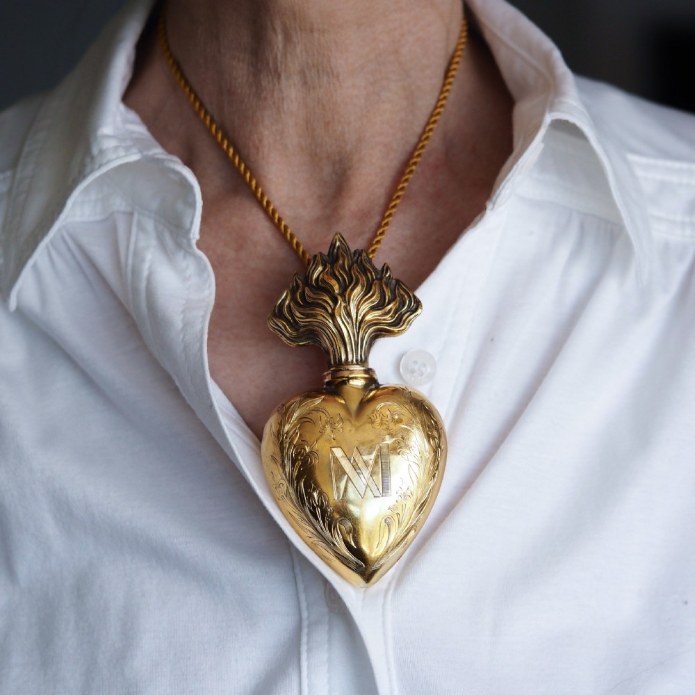 A 19th-century French silver-gilt heart-shaped scent bottle featuring an engraved monogram, foliate scrollwork, and a flame-shaped stopper. View XII