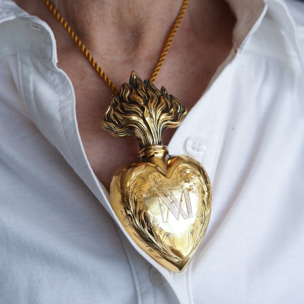 A 19th-century French silver-gilt heart-shaped scent bottle featuring an engraved monogram, foliate scrollwork, and a flame-shaped stopper. View XIII