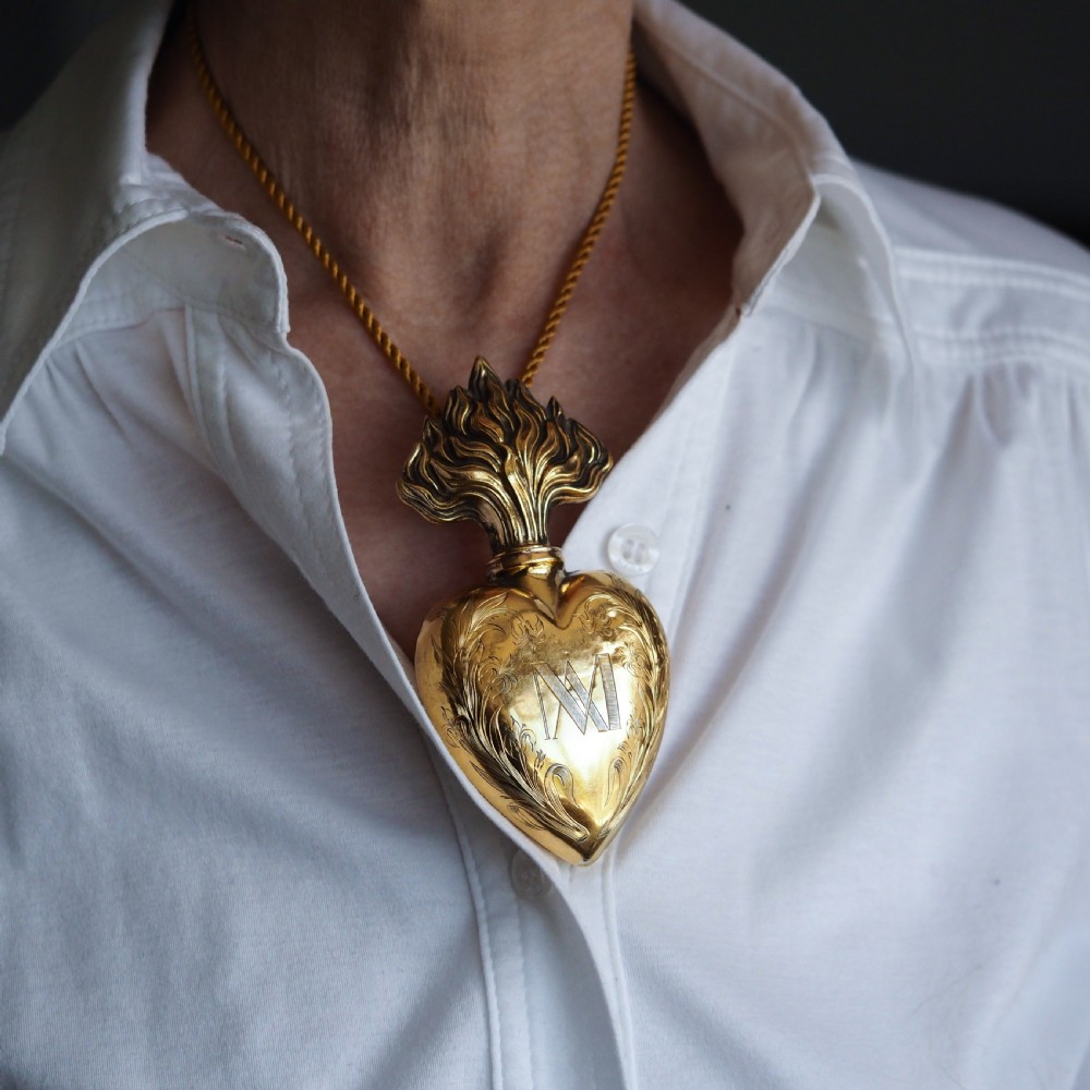 A 19th-century French silver-gilt heart-shaped scent bottle featuring an engraved monogram, foliate scrollwork, and a flame-shaped stopper. View XIV