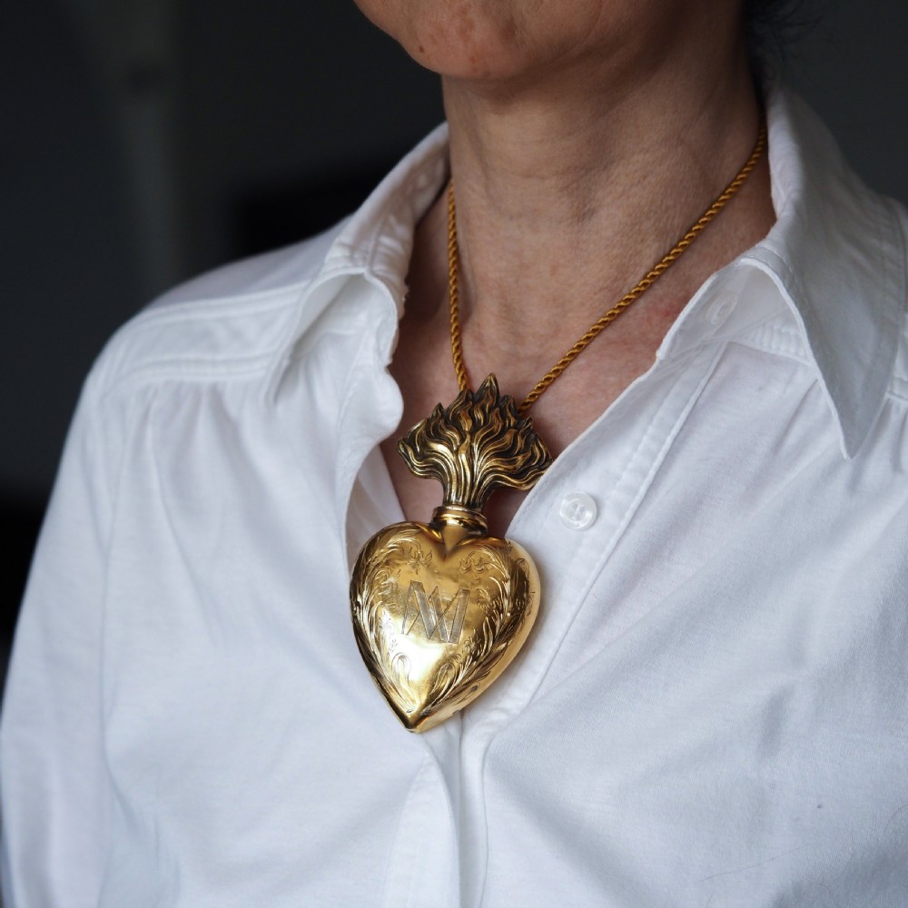 A 19th-century French silver-gilt heart-shaped scent bottle featuring an engraved monogram, foliate scrollwork, and a flame-shaped stopper. View XV