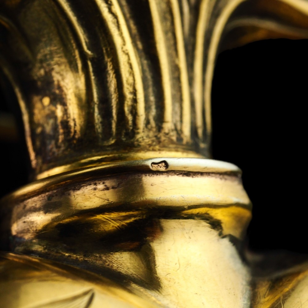 A 19th-century French silver-gilt heart-shaped scent bottle featuring an engraved monogram, foliate scrollwork, and a flame-shaped stopper. View XVII