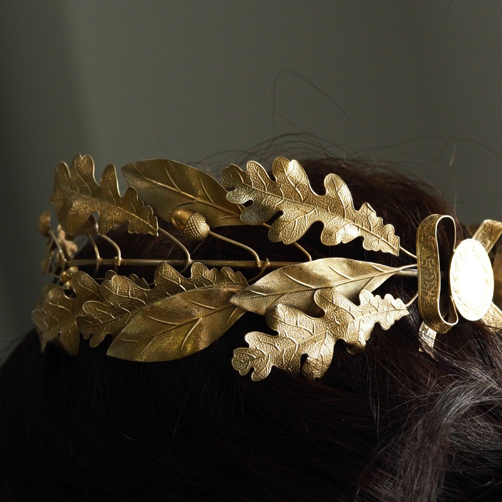 A 19th-century silver gilt foliate crown featuring detailed oak leaves, acorns, laurel leaves, and a central ribbon bow medallion. View II