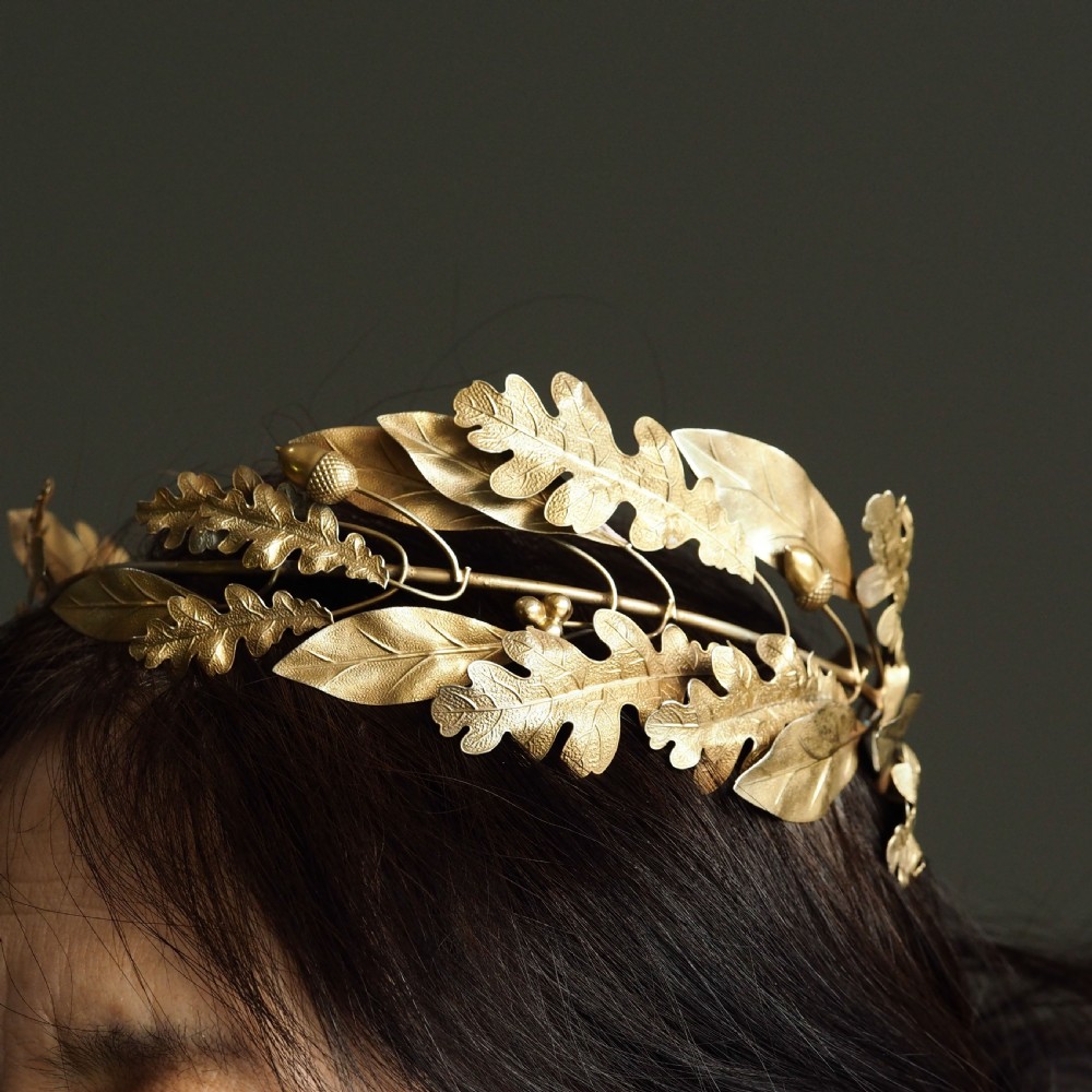 A 19th-century silver gilt foliate crown featuring detailed oak leaves, acorns, laurel leaves, and a central ribbon bow medallion. View III