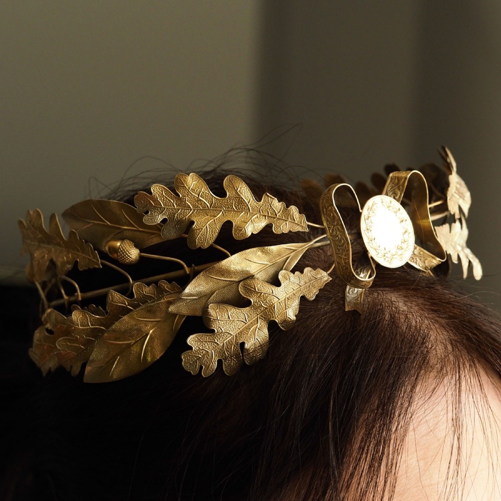 A 19th-century silver gilt foliate crown featuring detailed oak leaves, acorns, laurel leaves, and a central ribbon bow medallion. View VI