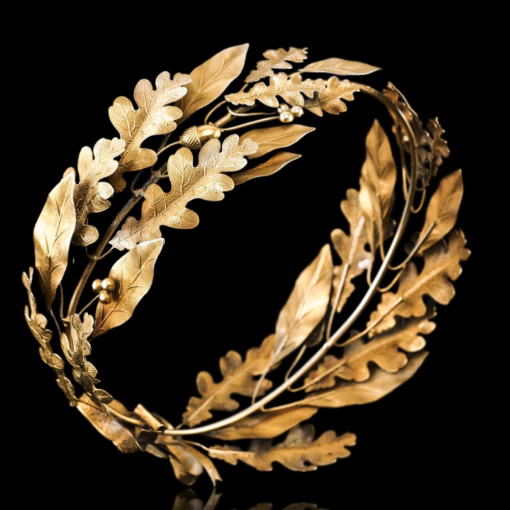A 19th-century silver gilt foliate crown featuring detailed oak leaves, acorns, laurel leaves, and a central ribbon bow medallion. View XIII