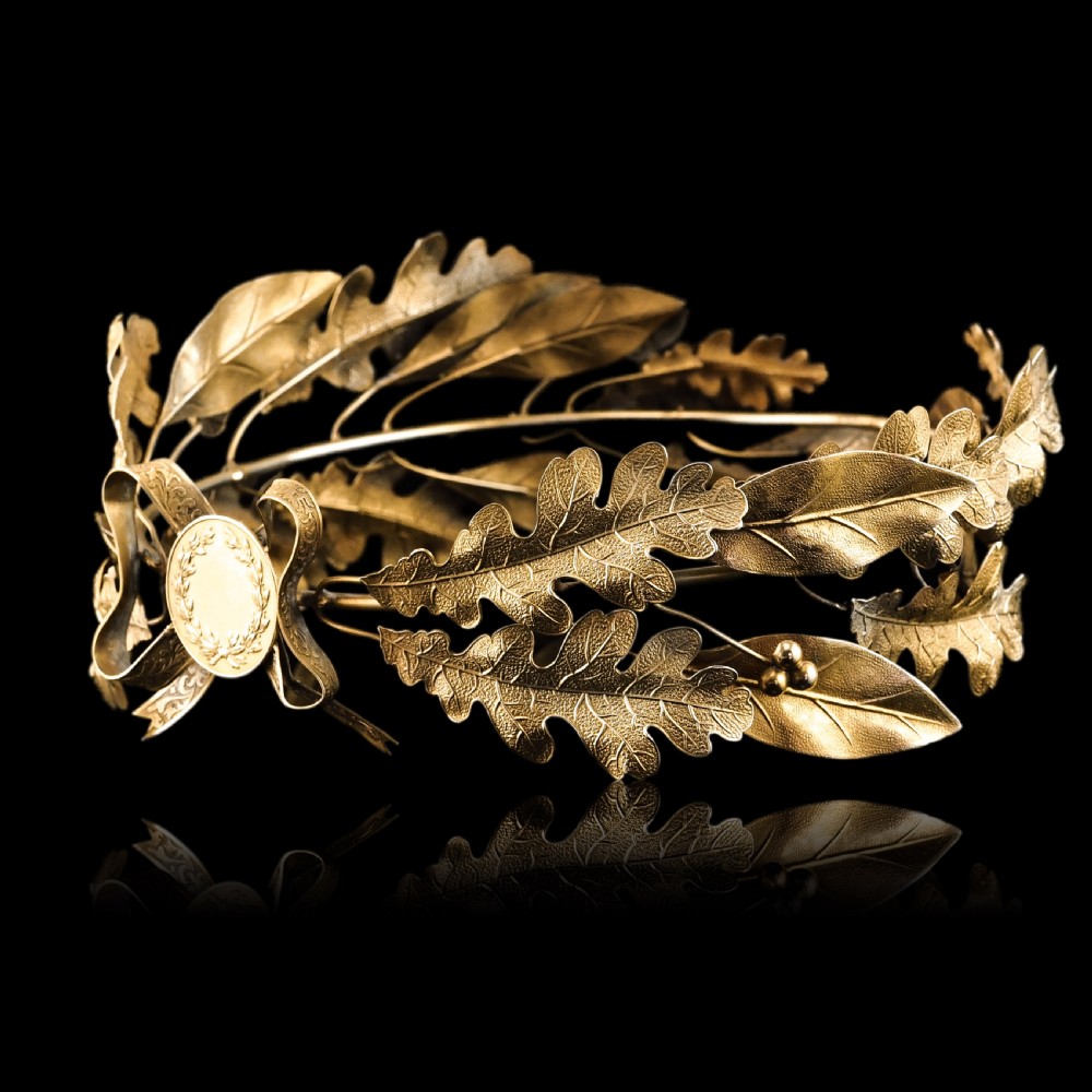 A 19th-century silver gilt foliate crown featuring detailed oak leaves, acorns, laurel leaves, and a central ribbon bow medallion. View XVI